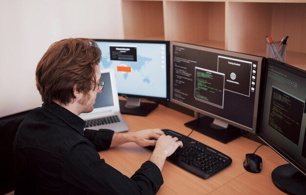 who-we-are male-programmer-working-desktop-computer-with-many-monitors-office-software-develop-company-website-design-programming-coding-technologies-1040180-7096